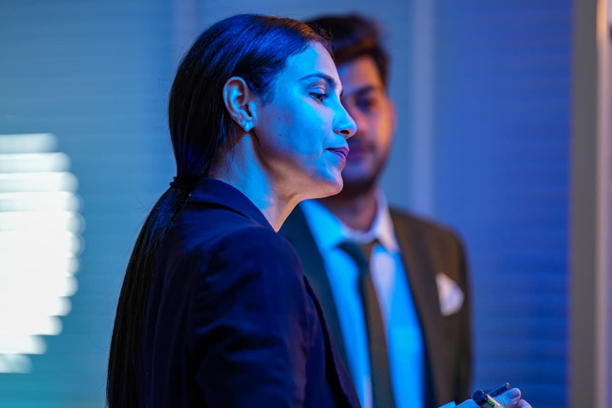 Business professionals presenting in a blue-lit modern office