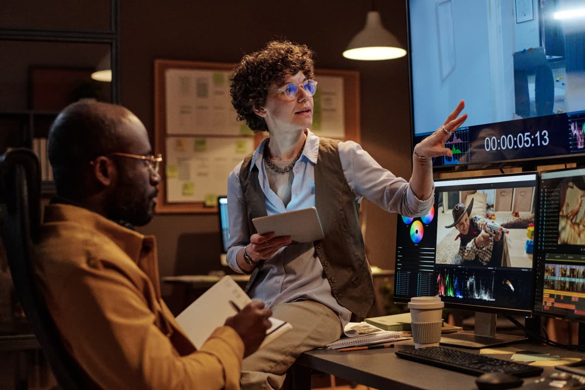 Editor and client reviewing a color-graded video project on studio monitors